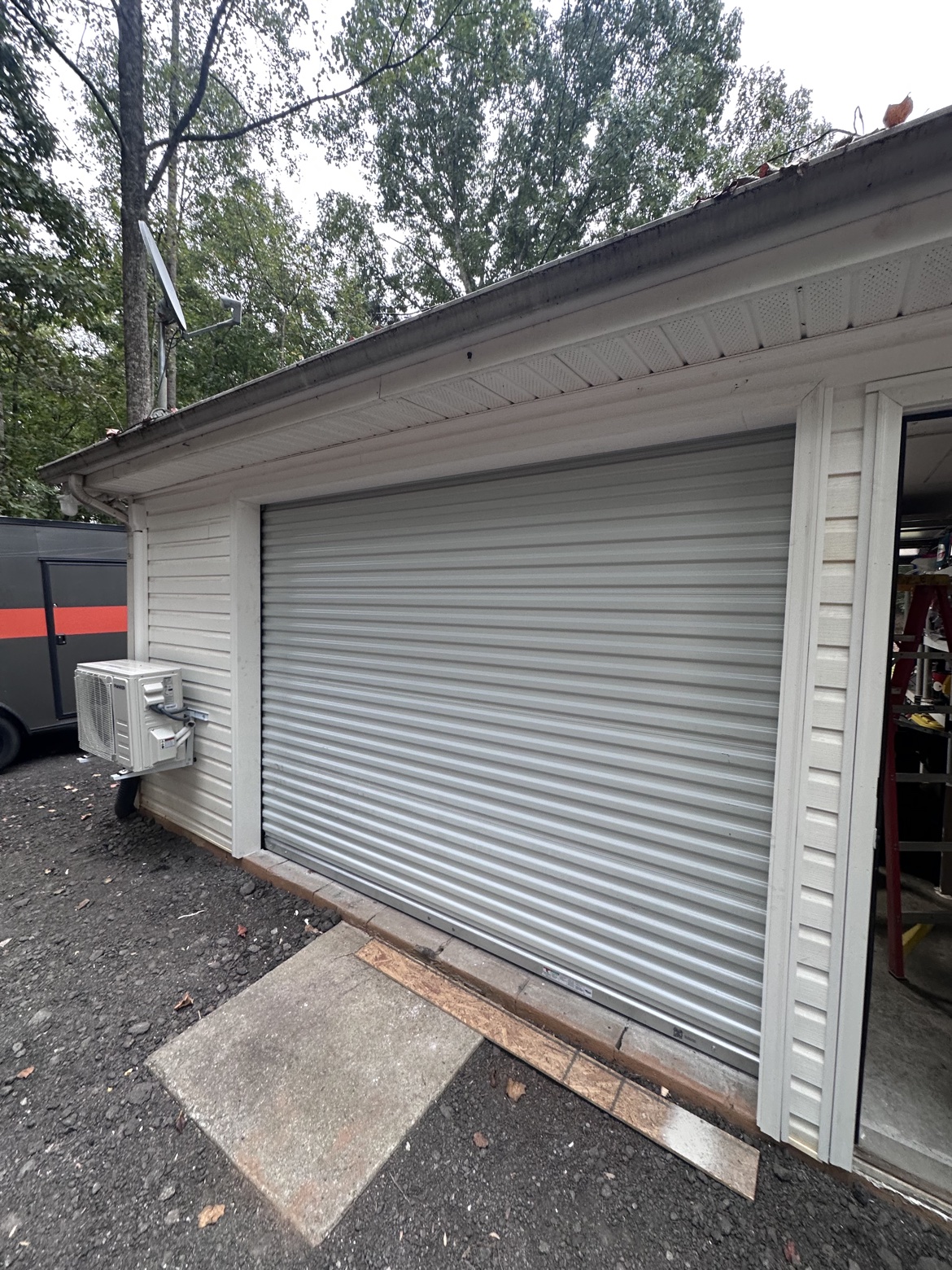 Wide exterior view of a white Janus commercial roll-up door installed on a building