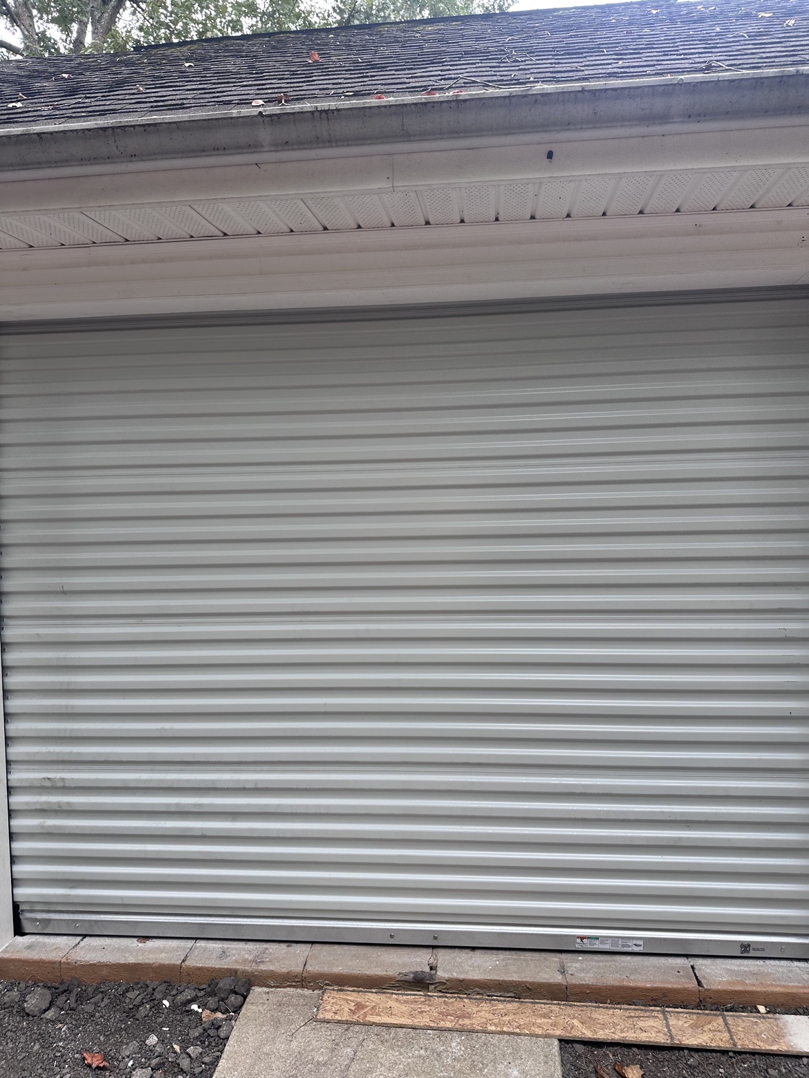 Exterior close-up of a white Janus commercial roll-up door curtain